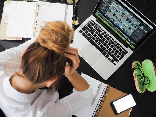 A womman anxiously working at the computer.