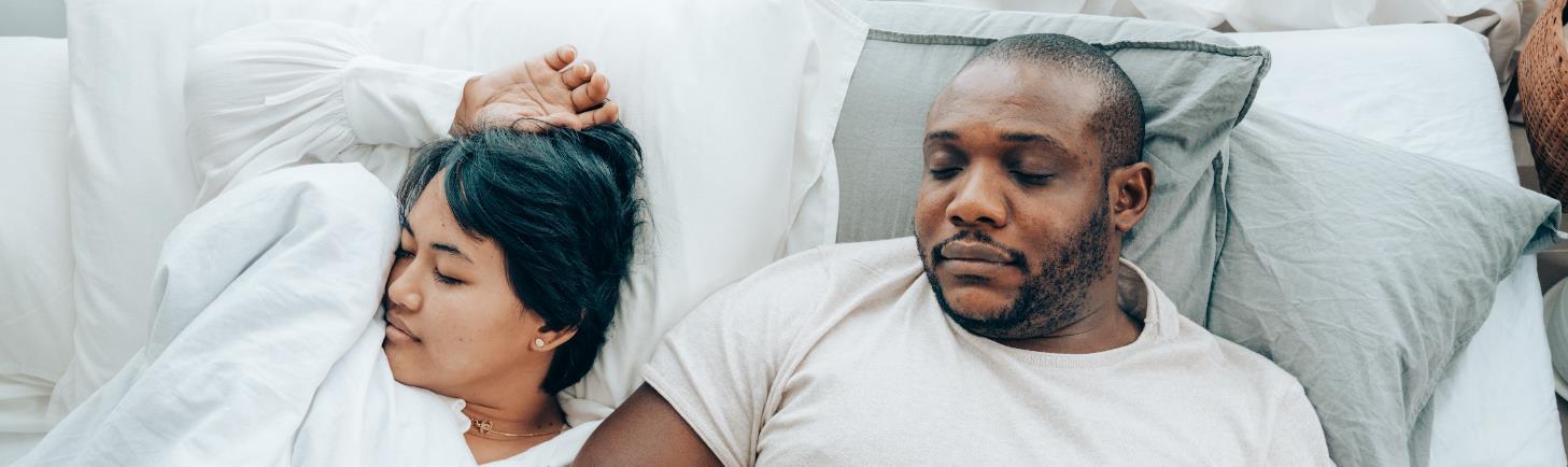 A couple sleeping in bed.